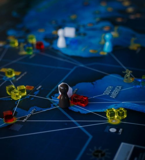 Close-up of board game setup with miniatures and cubes depicting strategic play.